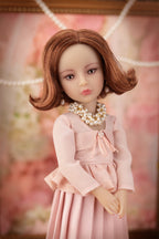 Lou in a pink dress with a blurred floral background