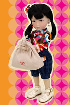 Doll holding a beige bag against a colorful geometric patterned background