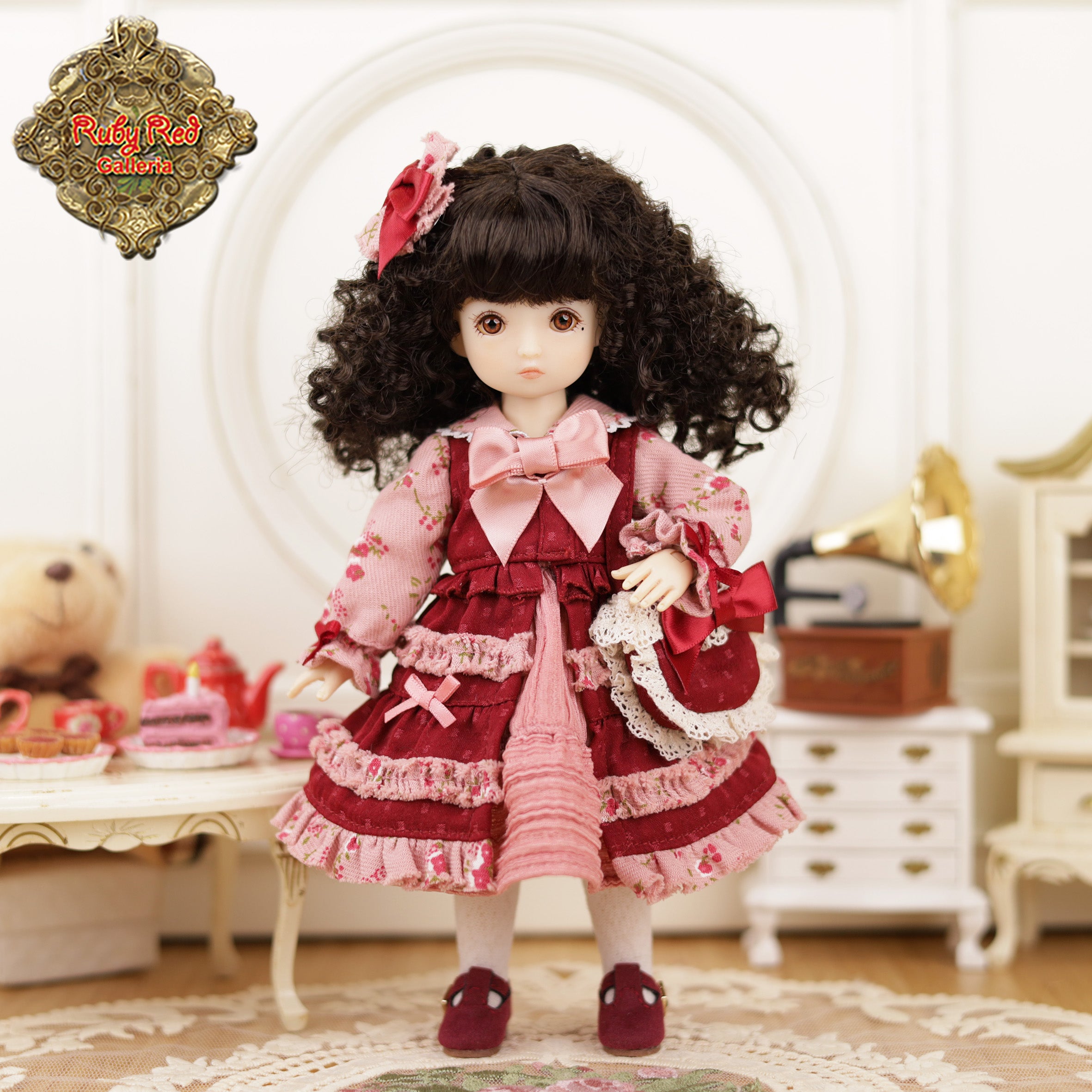 Doll in a vintage-style room with a 'Ruby Red Dolls' logo.