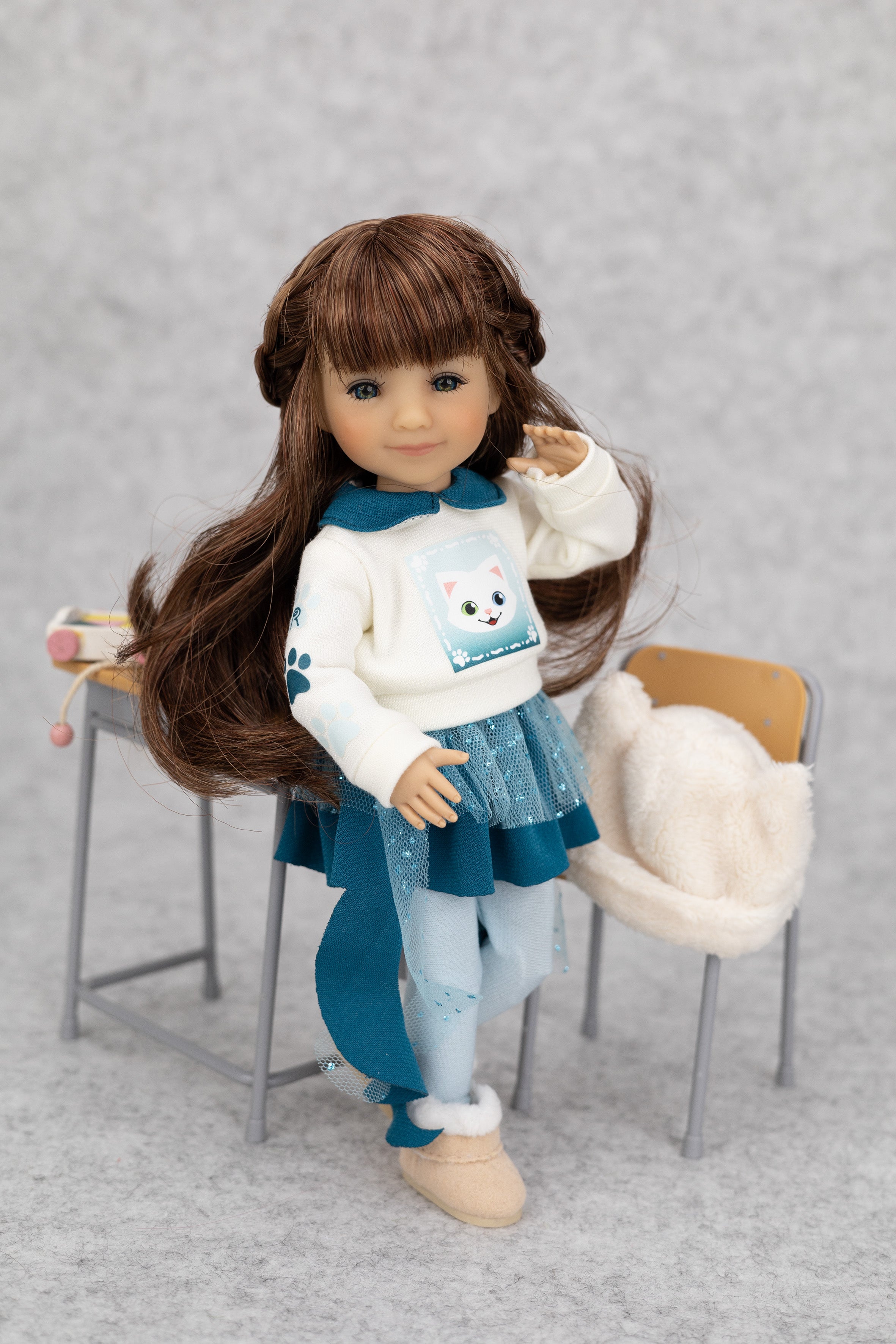 8" mini Fashion Friends doll with long brown hair wearing a white sweater with a bear design, blue skirt, and beige shoes on a gray background.