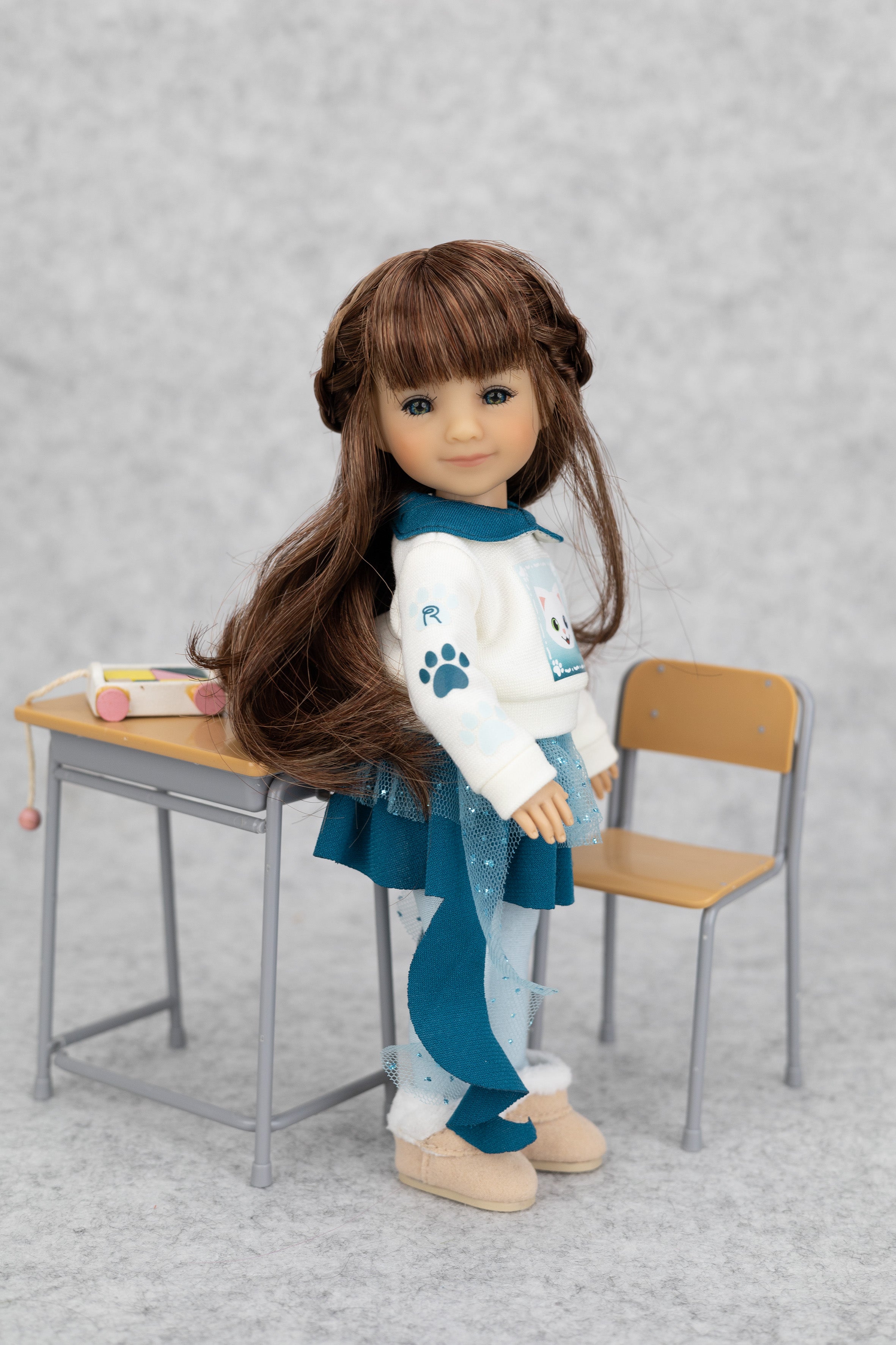 8" mini Fashion Friends doll with long brown hair sitting on a small desk with a chair against a gray background