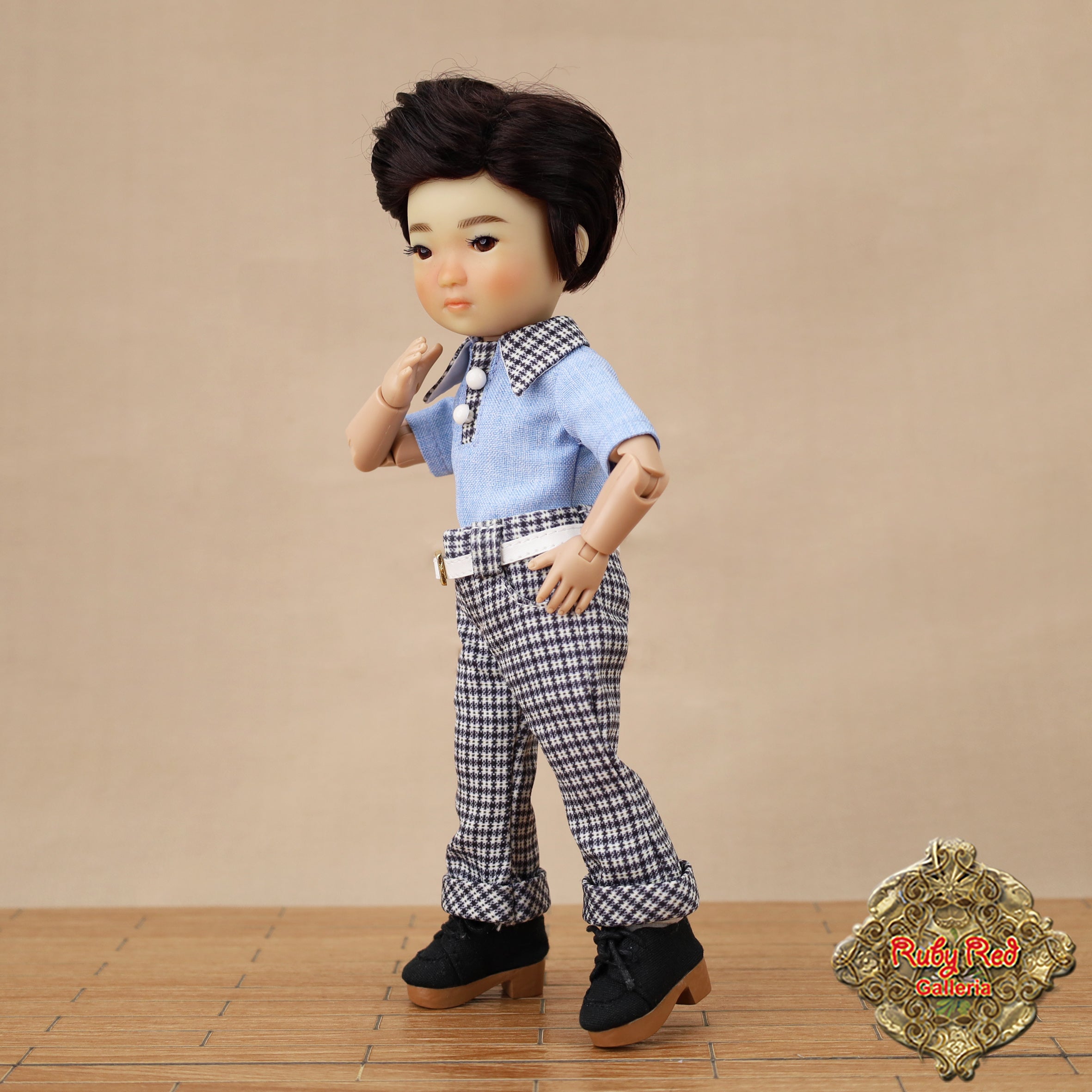Doll wearing a blue shirt and checkered pants on a beige background with 'Ruby Red Dolls' logo.