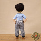 Doll wearing a blue shirt and checkered pants on a beige background with 'Ruby Red Dolls' logo.