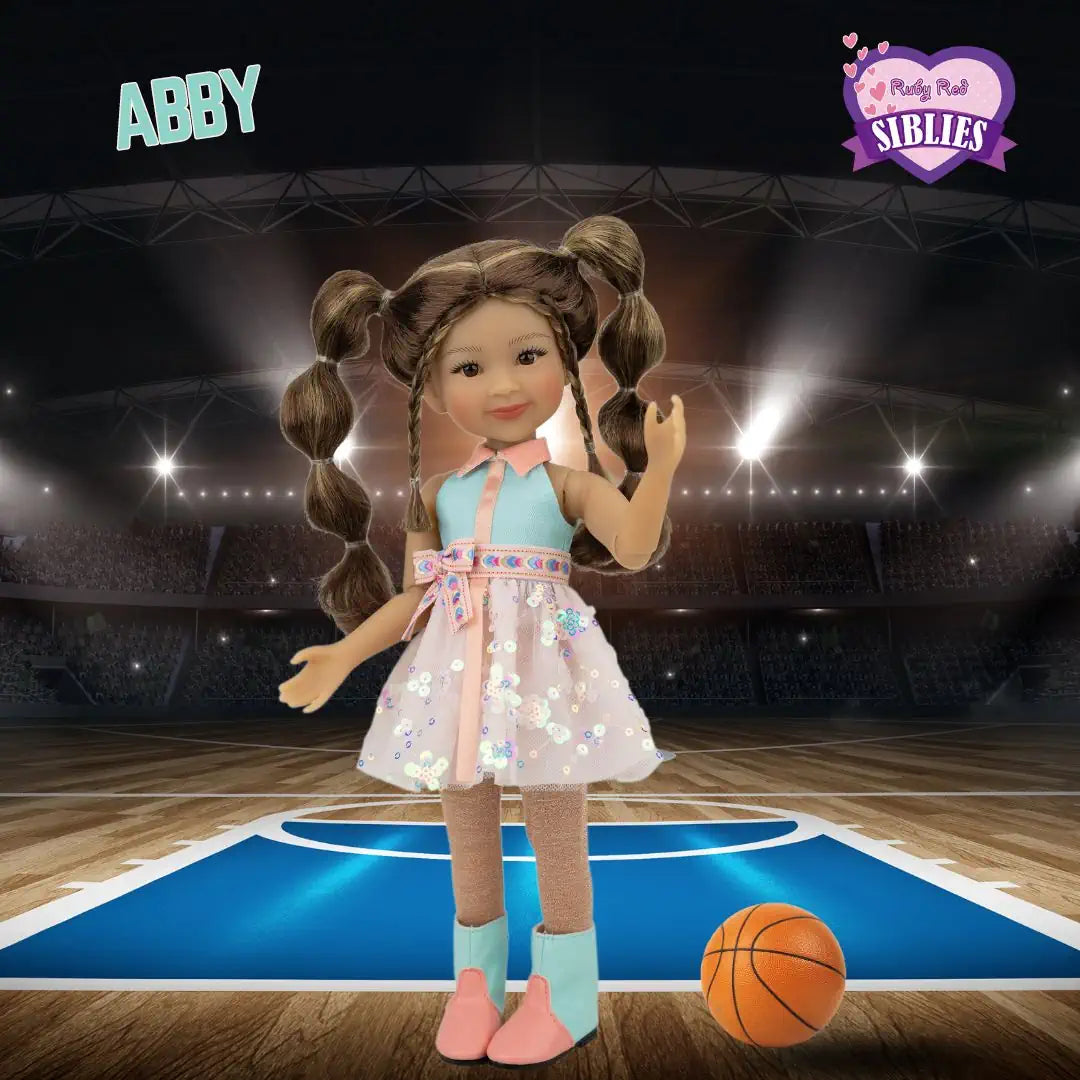 Doll named Abby standing on a basketball court with a basketball, against a dark background.