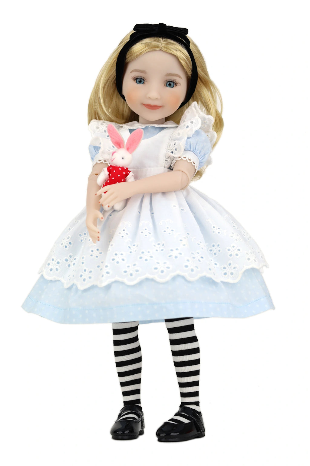 Doll in Alice in Wonderland outfit holding a rabbit plush toy on a white background