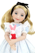 Doll in Alice in Wonderland outfit holding a rabbit plush toy on a white background