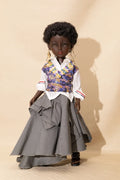 Doll wearing a floral vest, white shirt, and gray skirt against a beige background