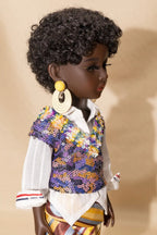 Doll wearing a colorful floral vest over a white shirt on a beige background