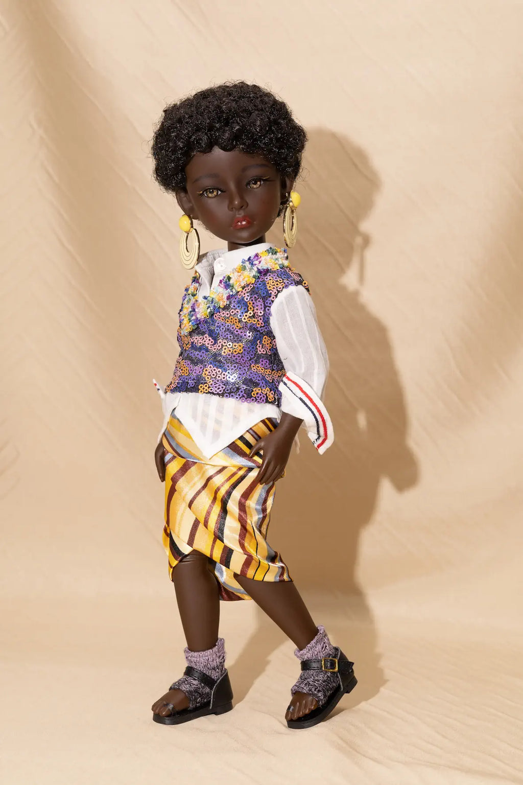 Doll with African-inspired outfit on a beige background