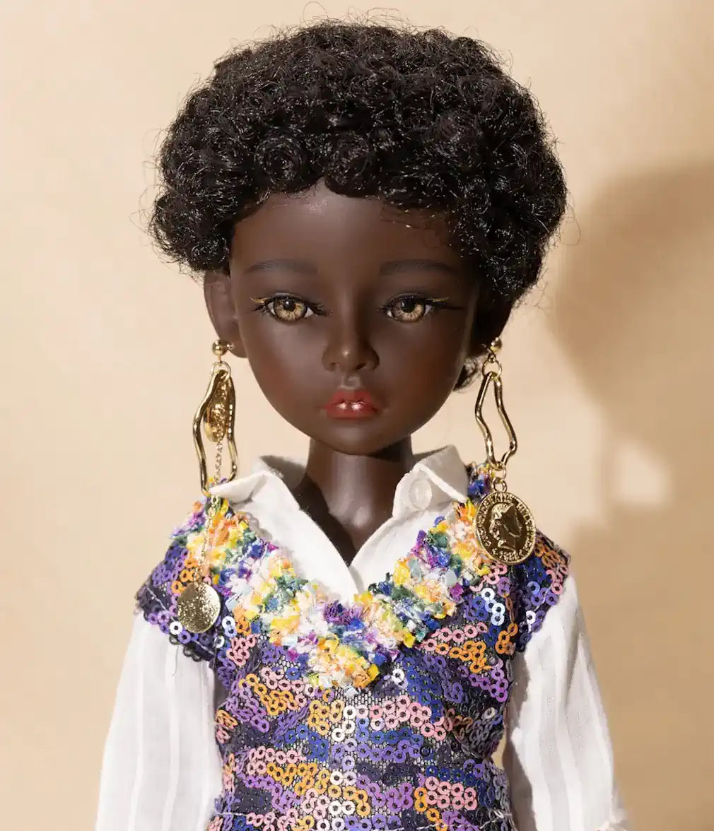 Doll with dark skin, curly hair, and colorful sequined top against a beige background