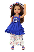 Doll wearing a blue dress with a floral design, white pants with star patterns, and a matching hat on a white background.