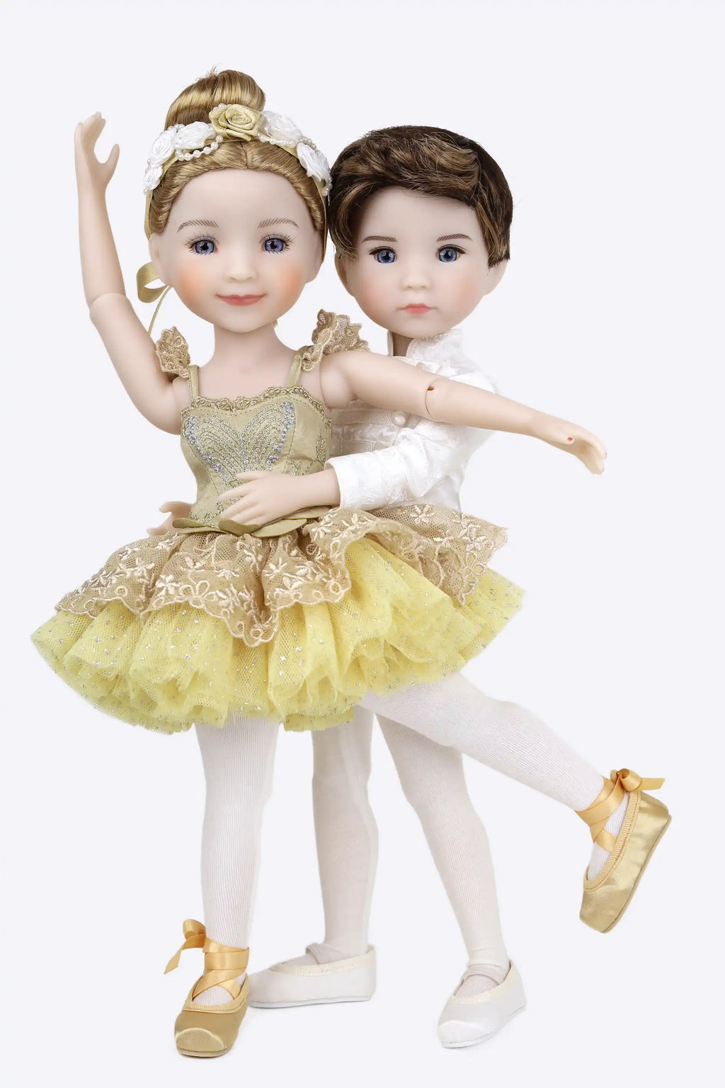 Two dolls in ballet costumes, one in gold and white, the other in white and brown, on a white background.