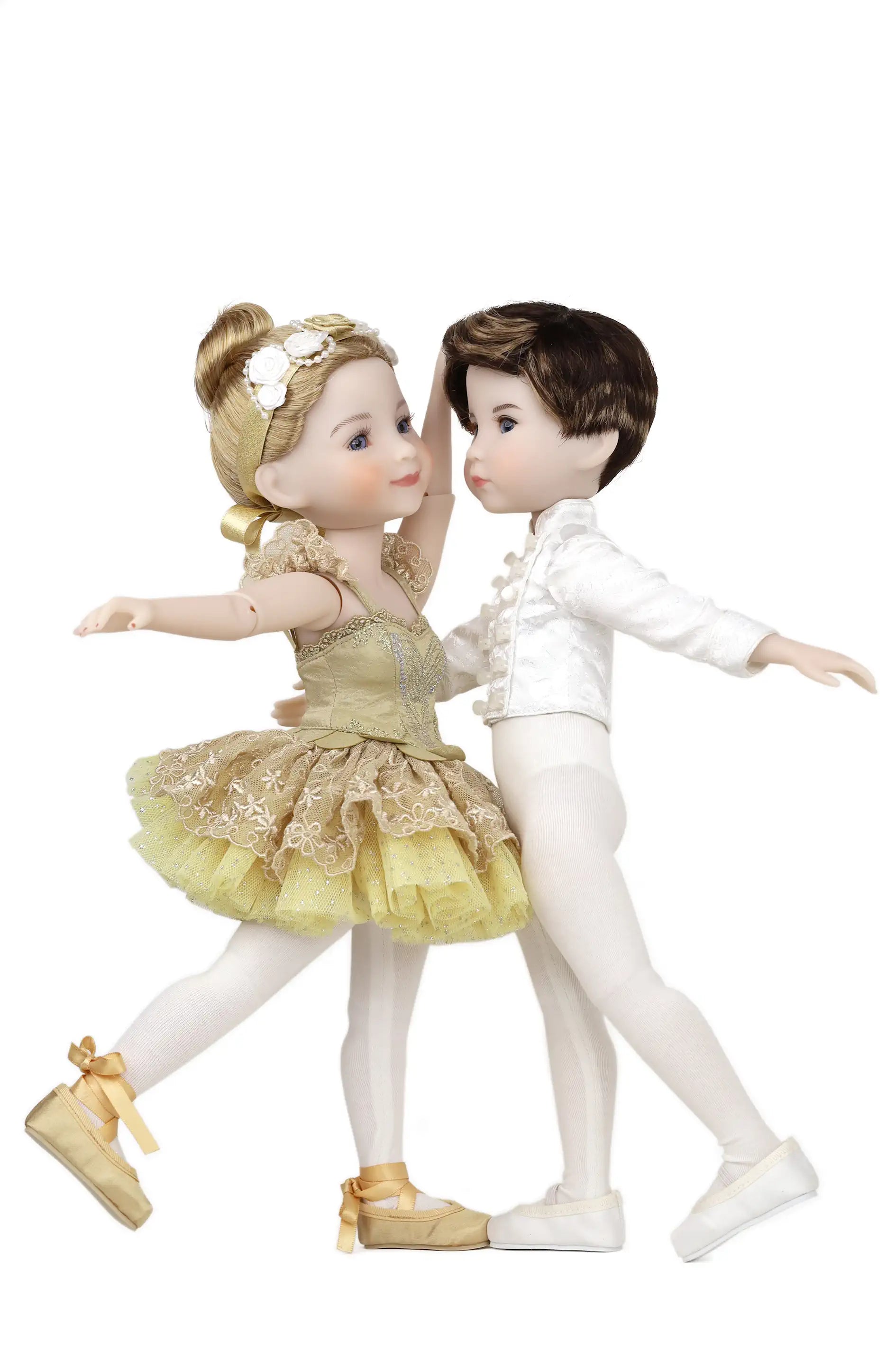 Two dolls in ballet costumes, one in gold and white, the other in white and brown, on a white background.