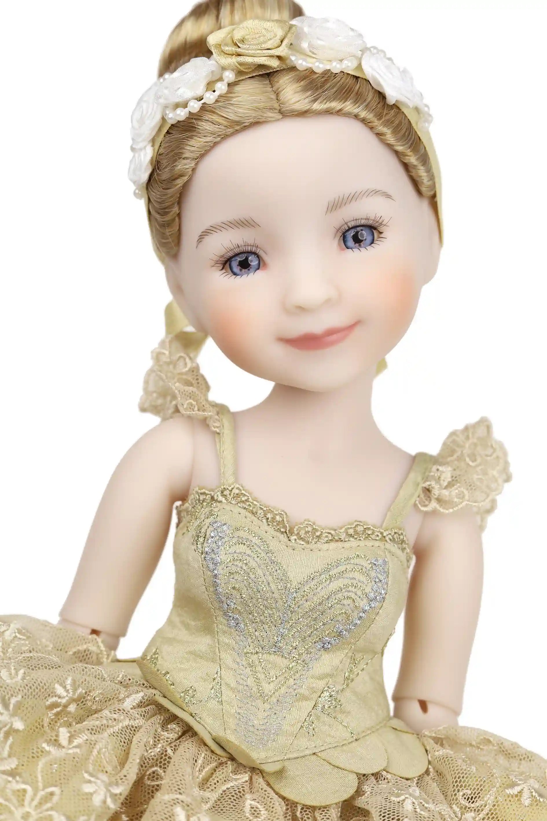 Doll in a detailed yellow dress with floral headpiece on a white background