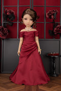 Doll in a red off-shoulder dress against a decorative wall with roses.