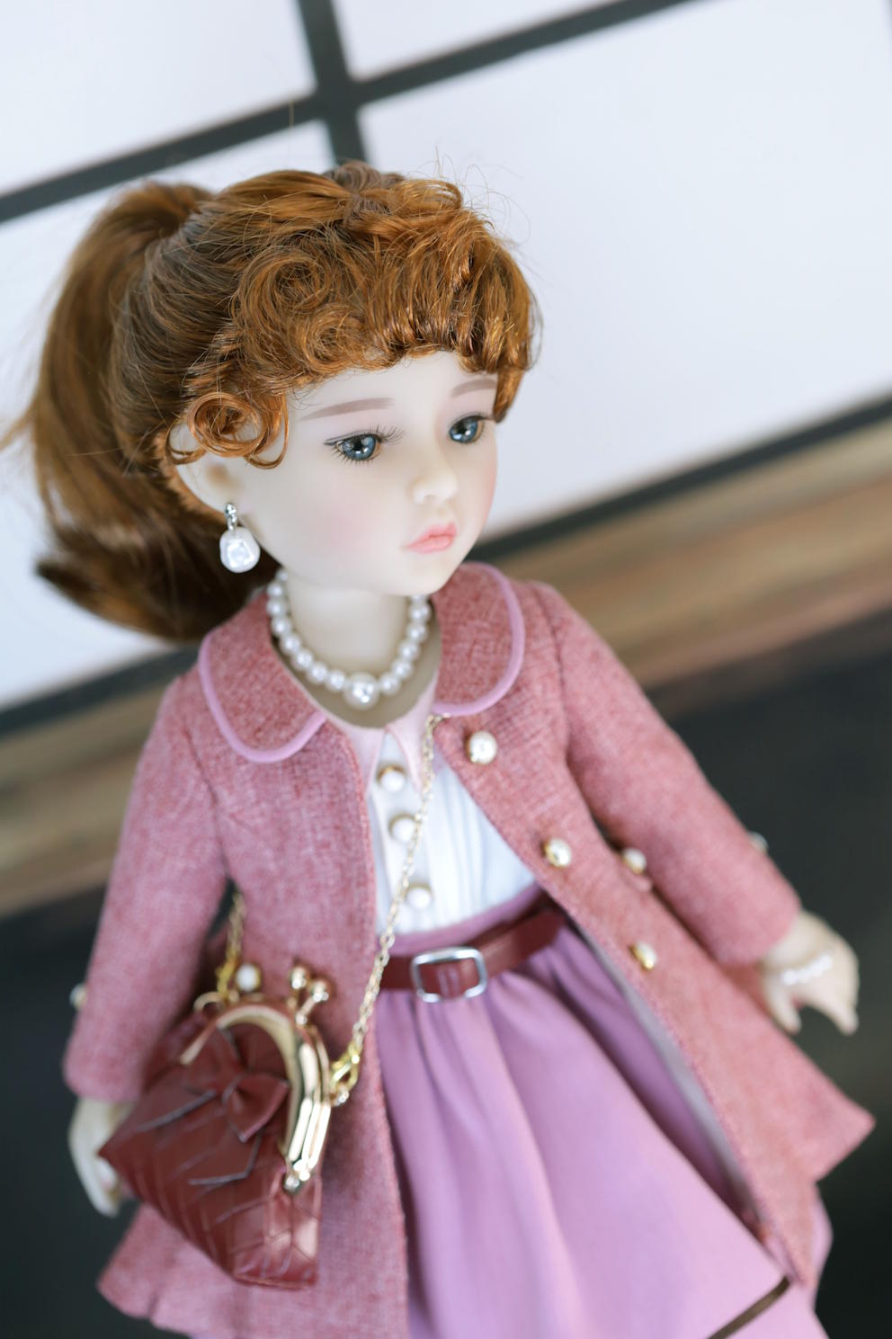 Doll in a pink outfit with a white background