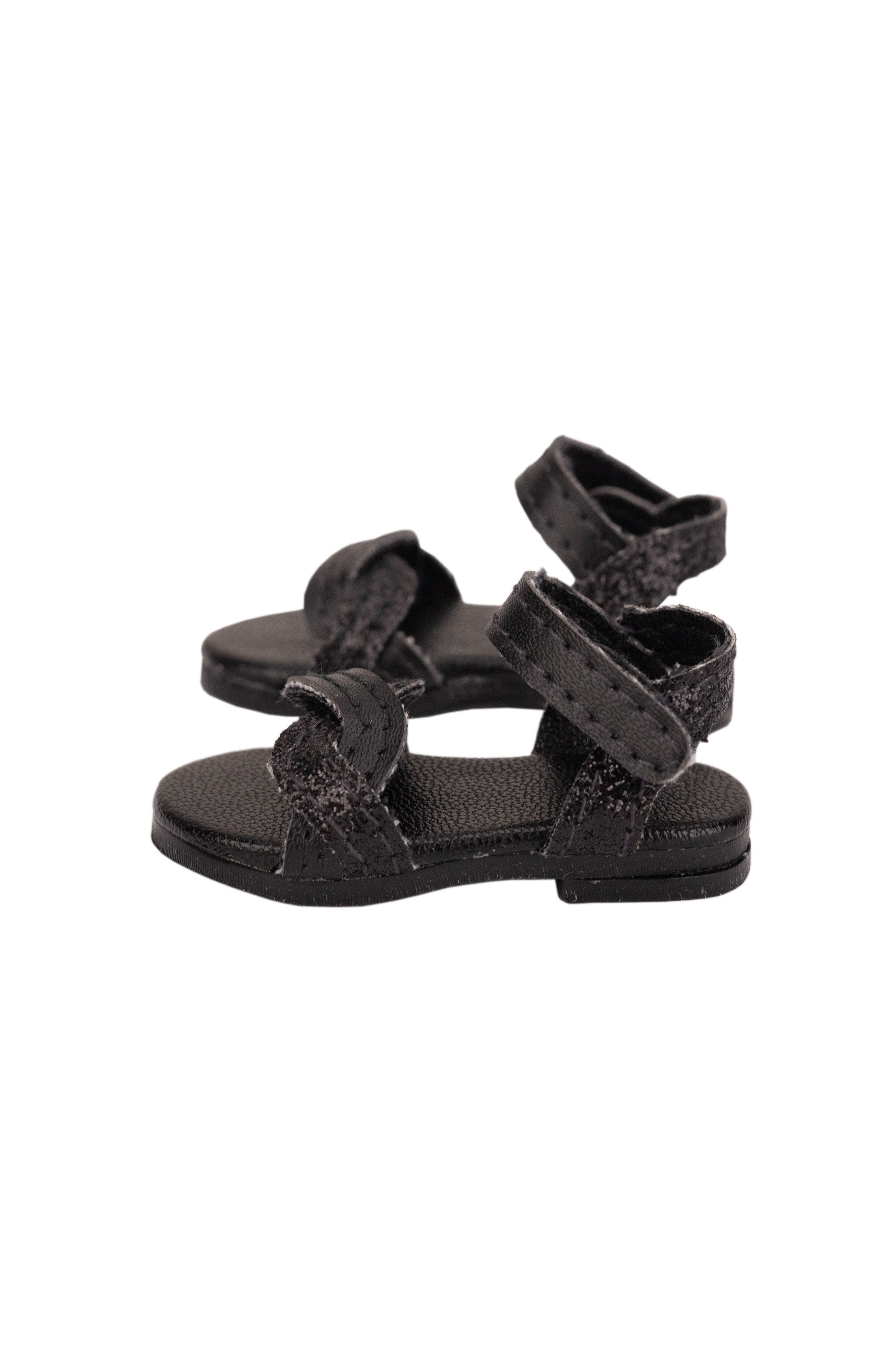 Black sandals with multiple straps on a white background