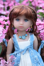 Doll with brown hair and blue eyes wearing a white dress with a blue shawl against a pink floral background