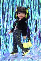 Doll with black jacket, patterned pants, and yellow shoes holding a yellow handbag against a colorful, abstract background.