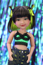 Doll with green and black hair and outfit against a colorful, blurred background
