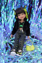 Doll with black jacket and green pants sitting on a glittery purple and blue background