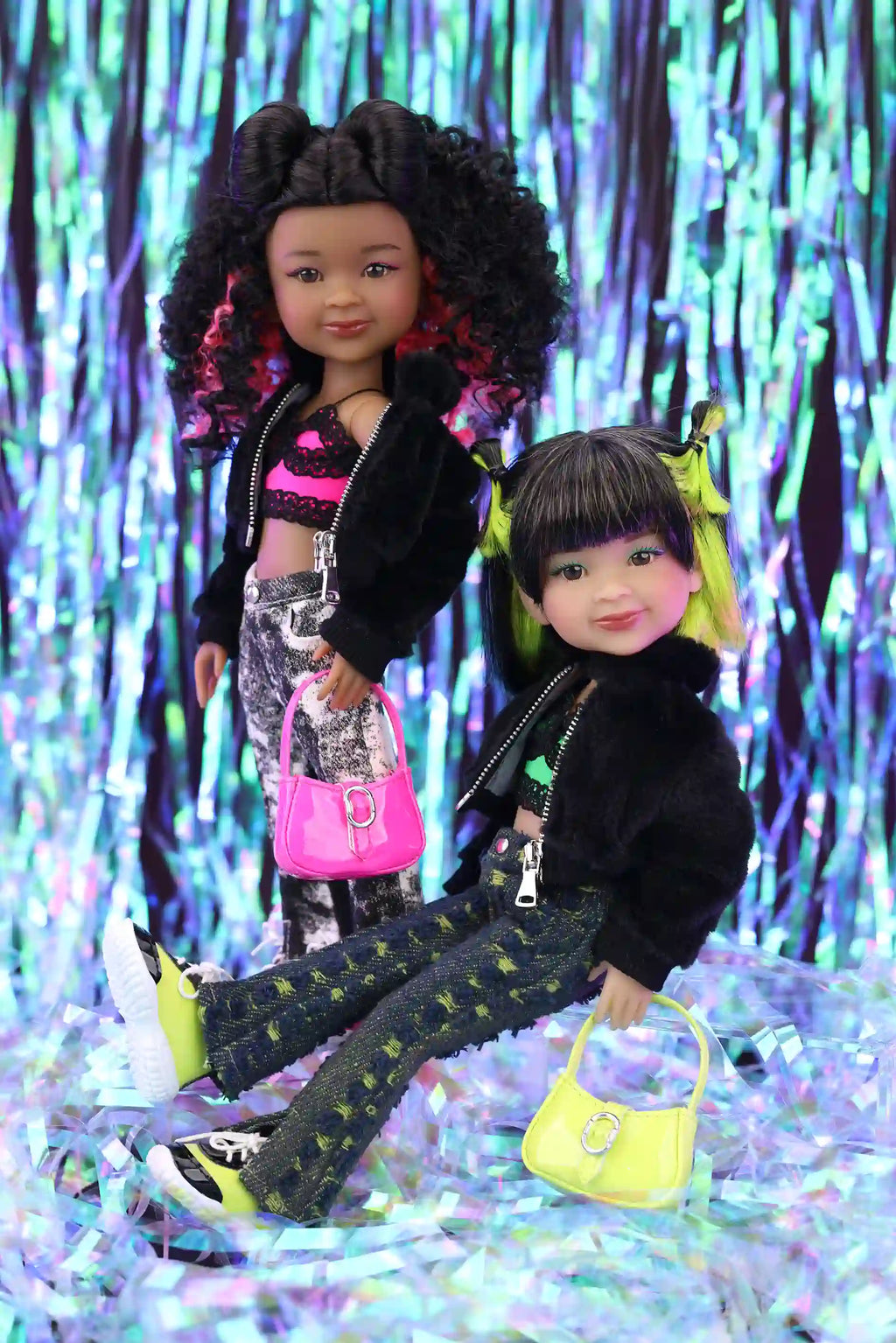 Two dolls standing in front of a colorful, glittery background