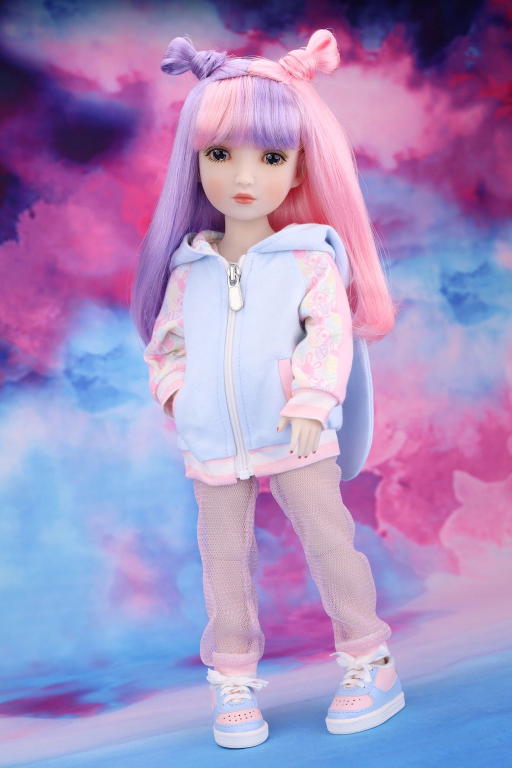 Doll with pastel-colored hair and outfit against a colorful, cloud-like background