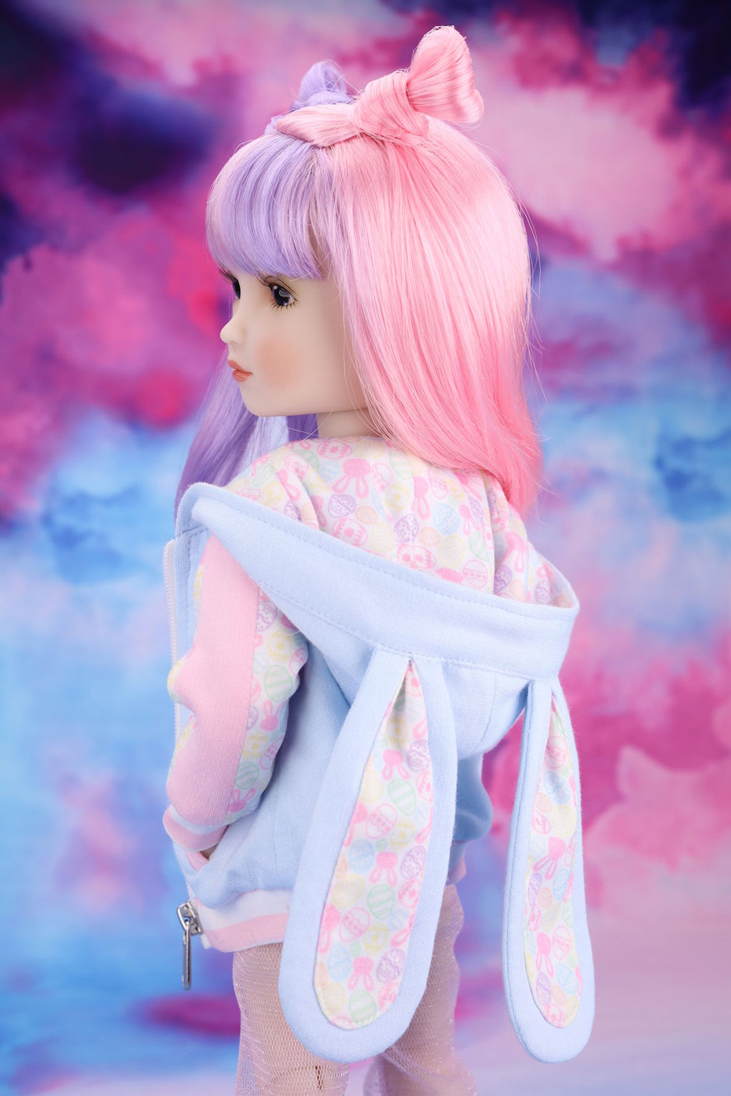 Doll with pastel-colored hair and outfit against a colorful, abstract background