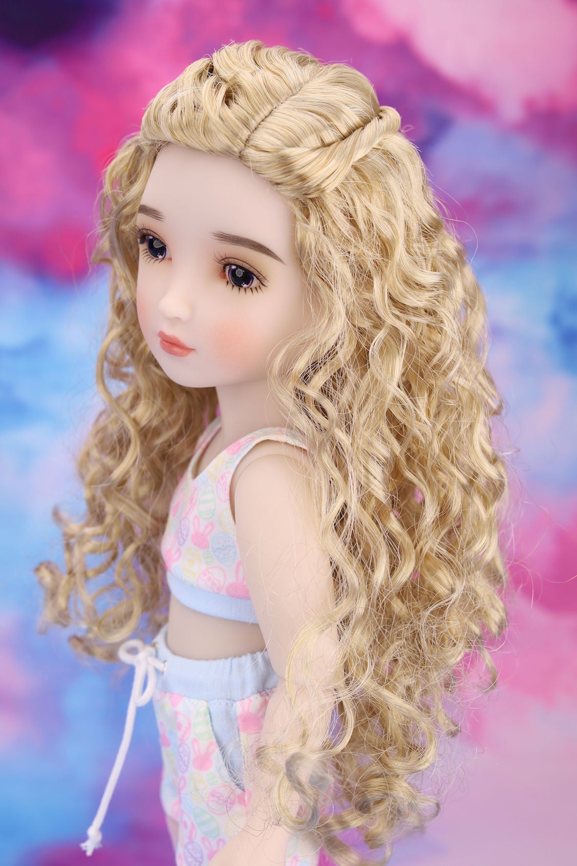 Doll with long blonde hair against a colorful background
