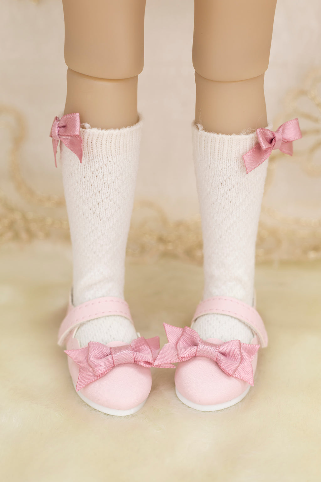 White socks with pink bows and matching shoes on a neutral background