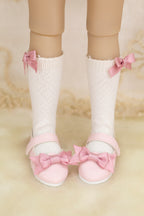 White socks with pink bows and matching shoes on a neutral background
