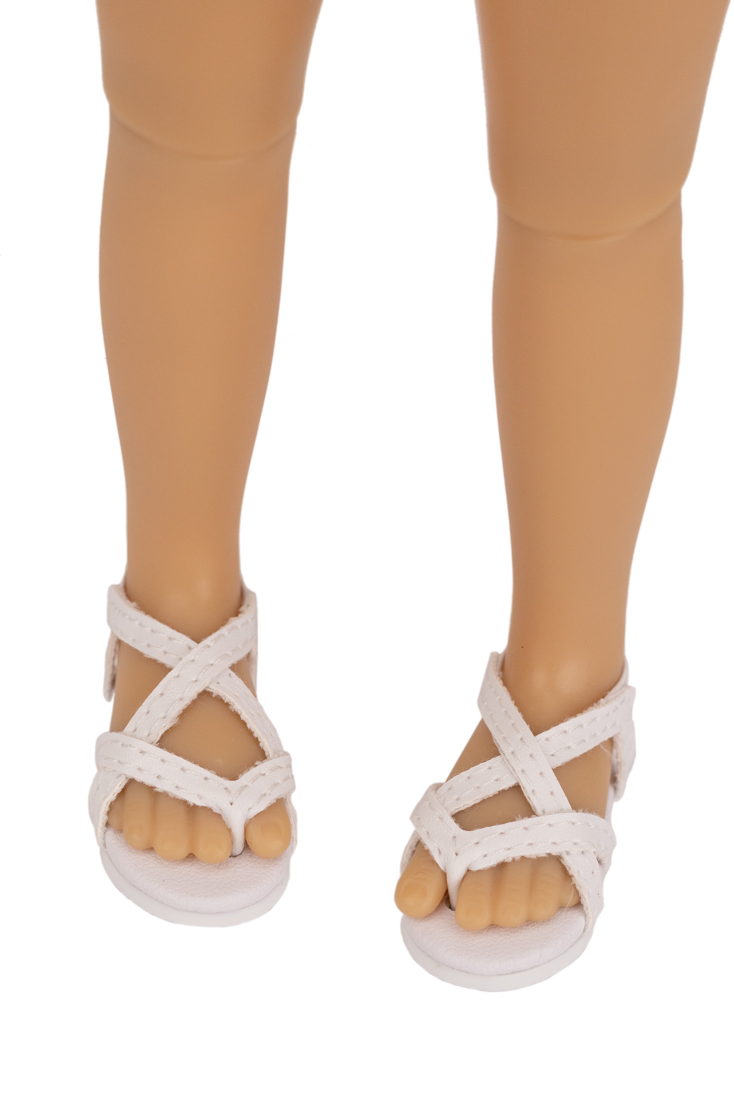 White sandals worn by a doll on a white background