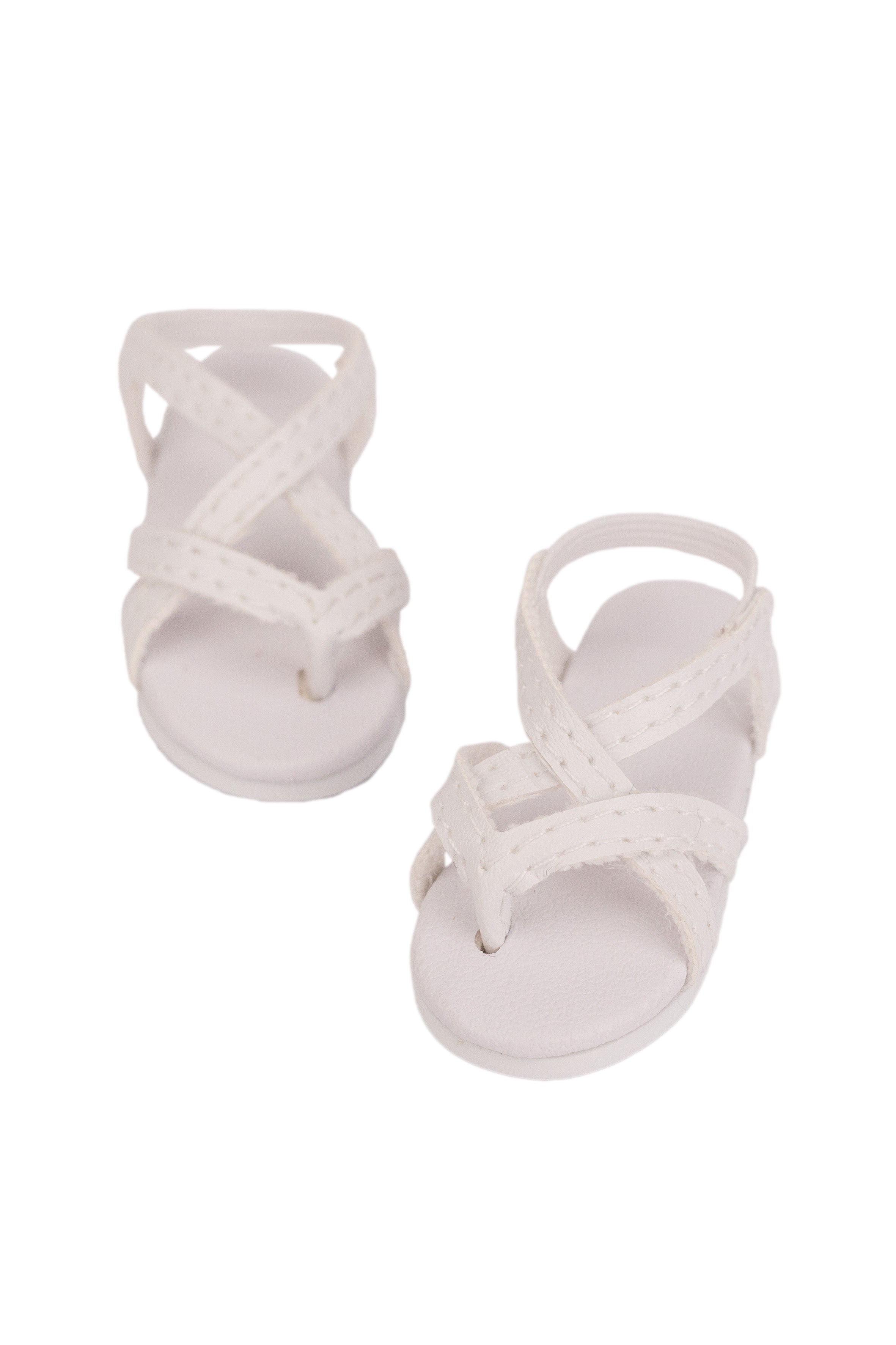 Pair of white sandals with criss-cross straps on a white background