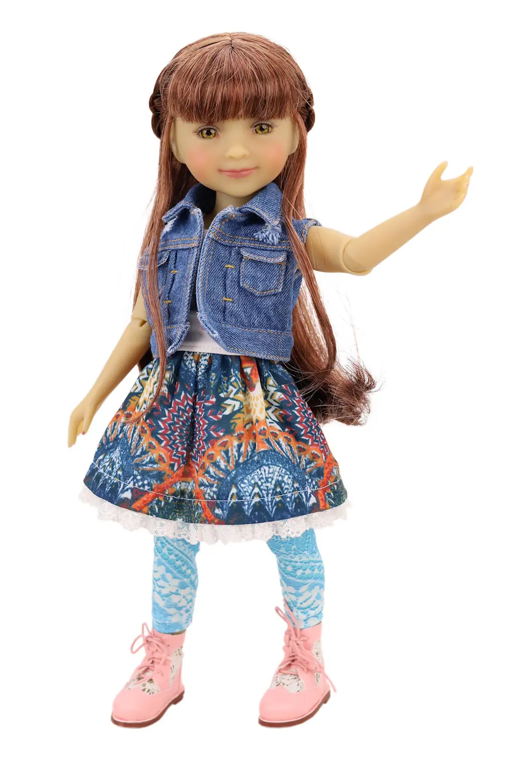 Doll wearing a denim vest, colorful dress, and pink shoes on a white background