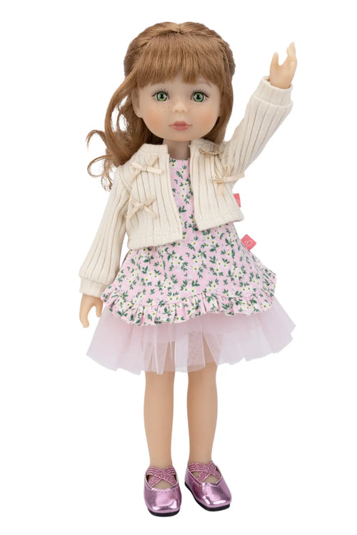 Doll wearing a floral dress with a white cardigan on a white background