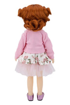 Doll with red hair styled in pigtails, wearing a pink sweater and floral skirt on a white background.