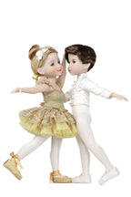 Two dolls in ballet costumes, one in gold and white, the other in white and brown, on a white background.