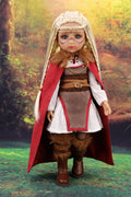 Doll in fantasy costume with red cloak and fur trim against a forest background
