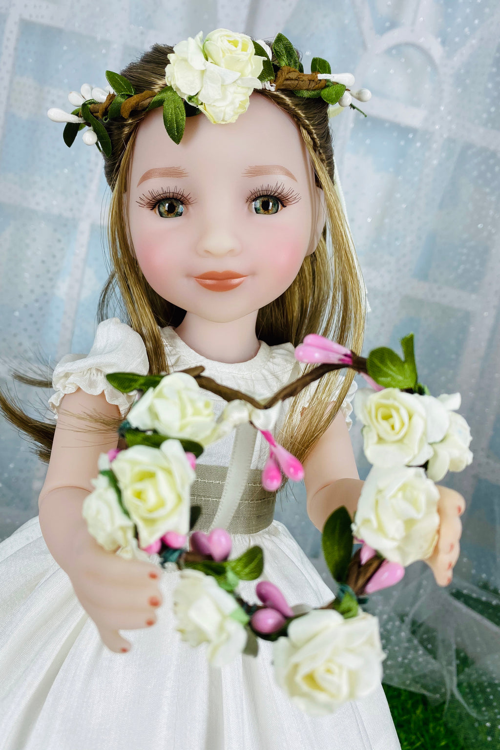 Doll with floral crown and bouquet against a light background