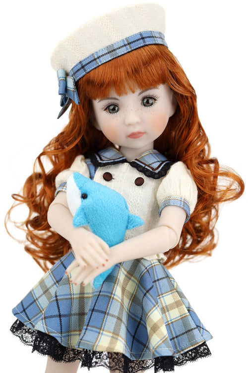 Doll with red hair wearing a plaid dress and holding a blue toy, on a white background