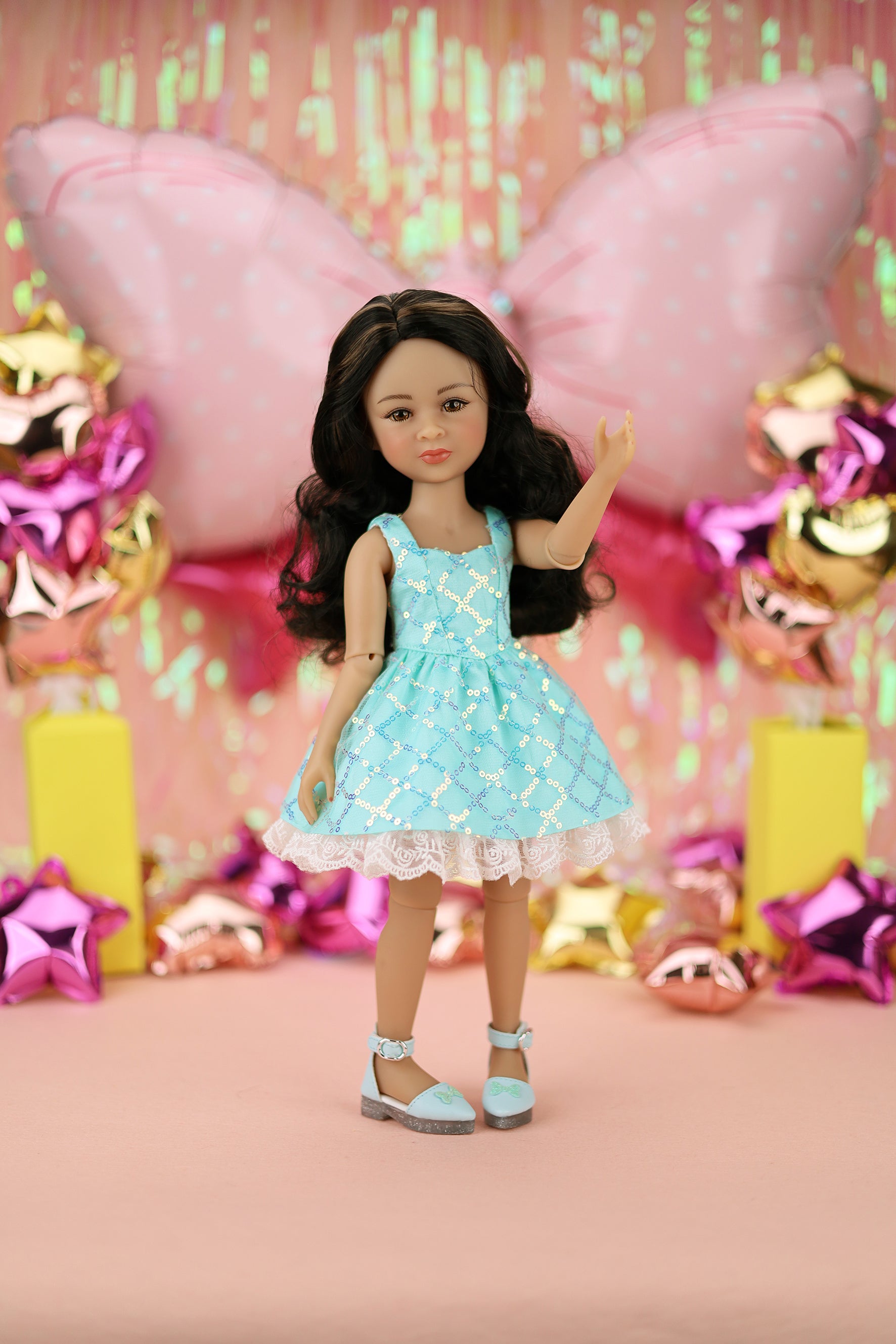 Doll with  a floral dress in front of colorful decorations