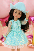 Doll wearing a turquoise dress and hat against a pink background