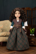 A doll with long curly brown hair wearing a detailed historical-style dress with a dark green and brown plaid skirt, a brown vest, and a dark teal top, posed in a miniature room setting.
