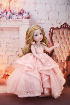 Doll in a pink gown standing in front of a decorative chair with a soft, warm background.