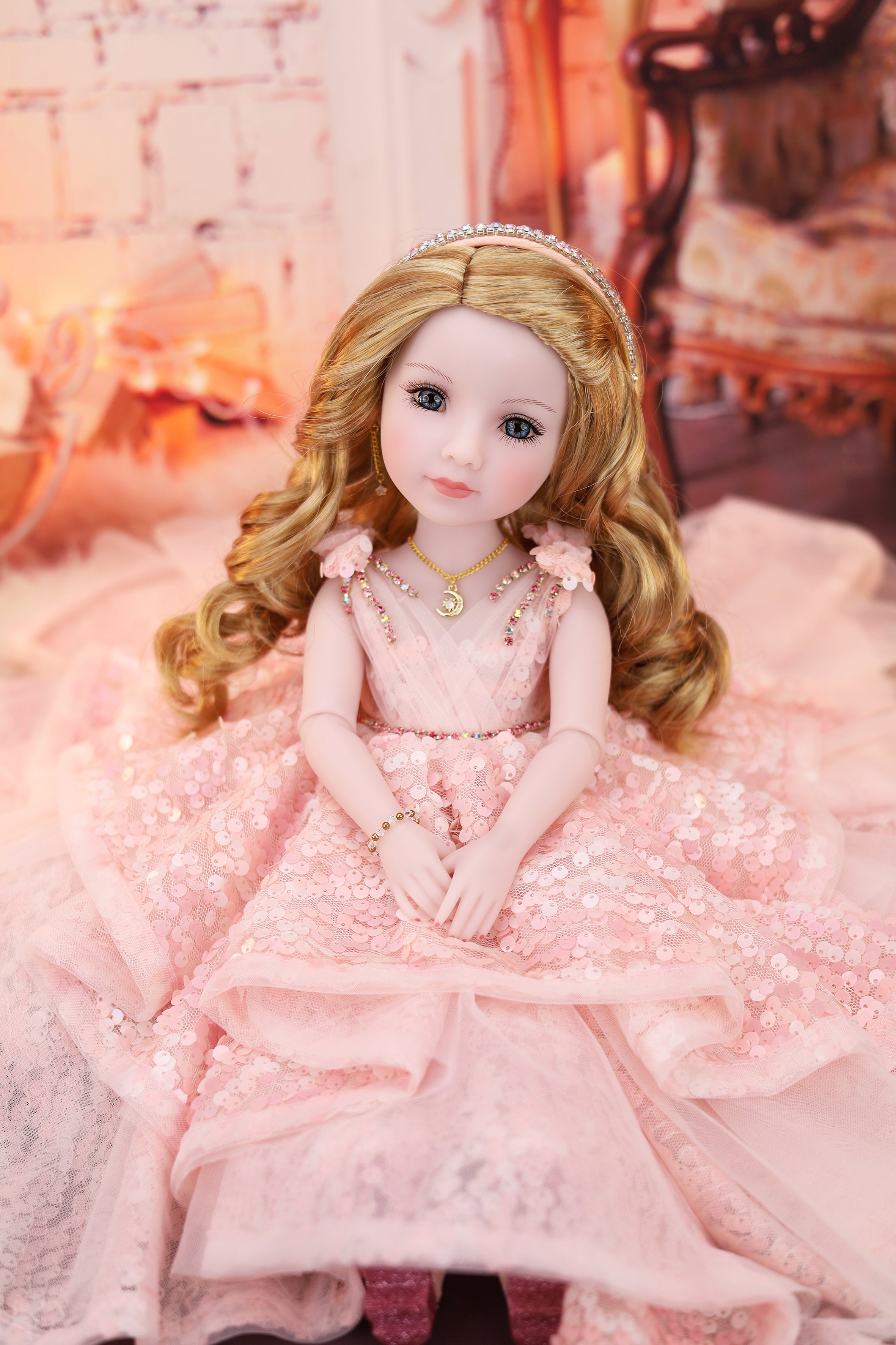 Doll in a pink dress in a softly lit room.