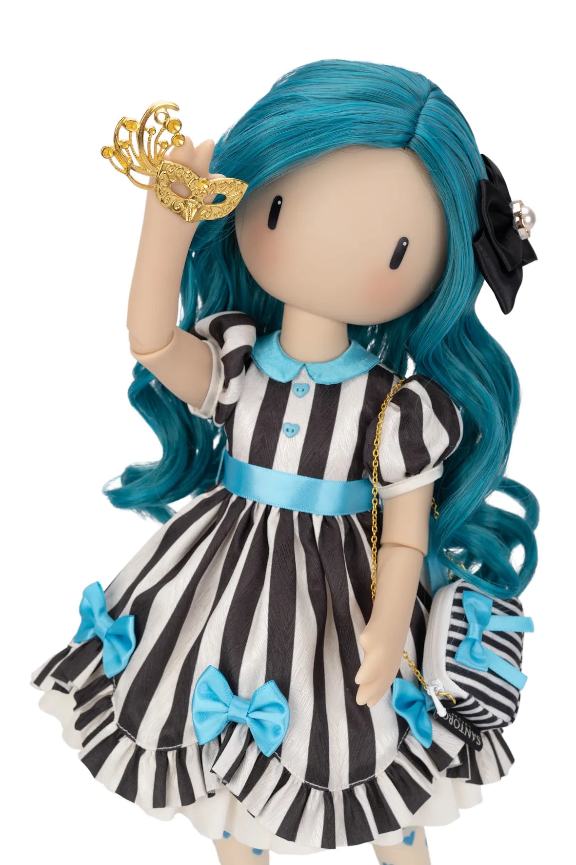 A Gorjuss doll with long teal-blue hair, a black-and-white vertically striped dress with light blue trim and bows, holding a gold masquerade mask, against a plain white background.
