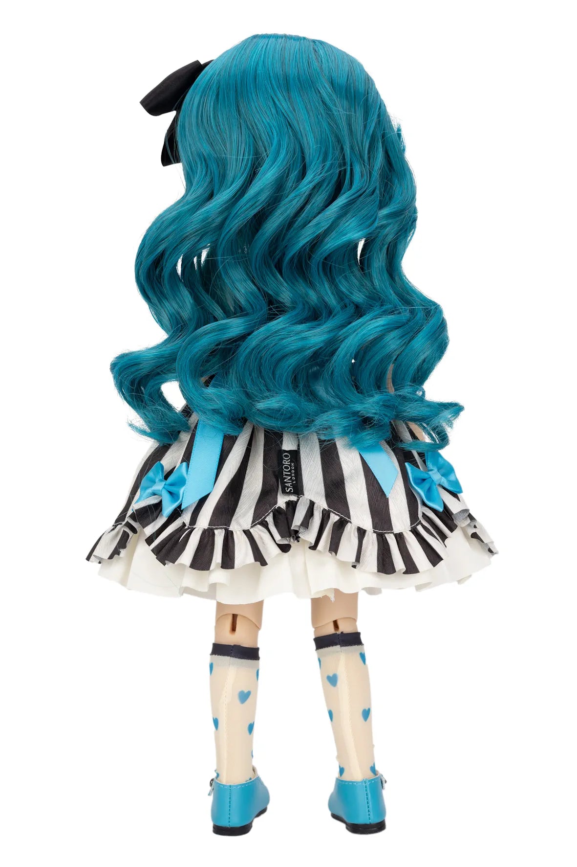 Back view of a Gorjuss doll with long, wavy teal-blue hair, wearing a black and white striped ruffled dress with blue bows, patterned socks, and blue shoes on a white background.