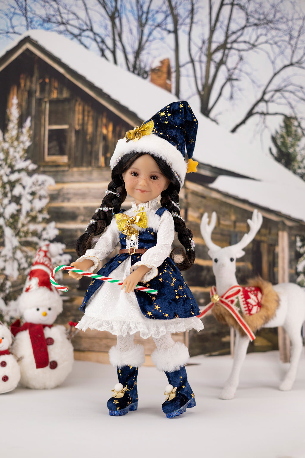 Doll in a festive outfit with a snowman and deer in the background