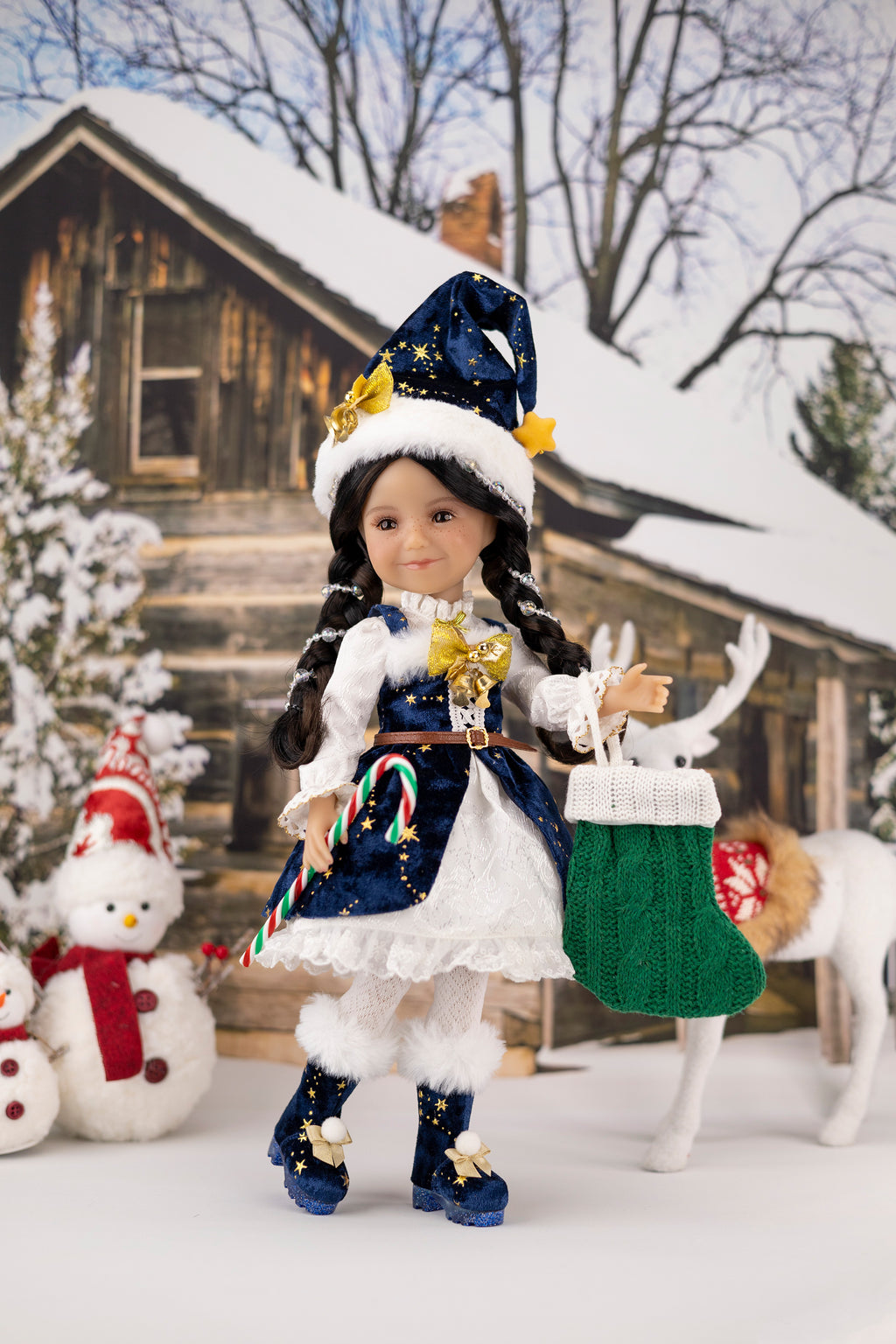 Doll in festive outfit with candy cane and starry hat in snowy scene