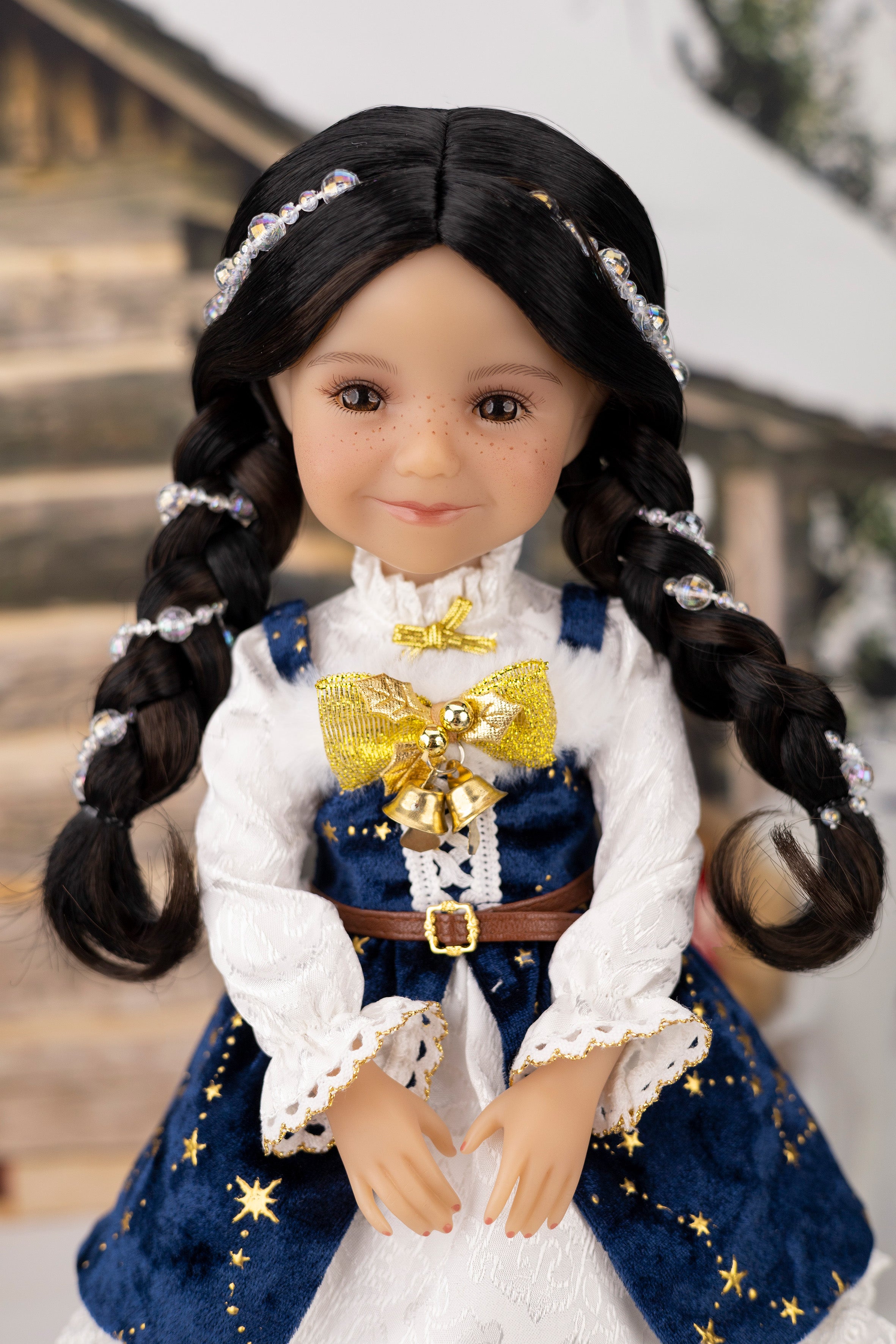 Doll with long braided hair wearing a blue and white outfit with gold accents.